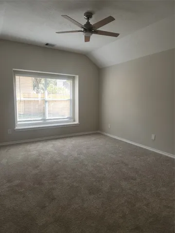 an empty room with windows and fan