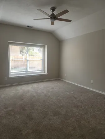 an empty room with windows and fan