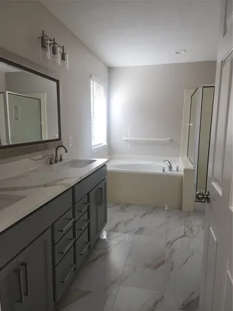 a bathroom with a tub sink and mirror