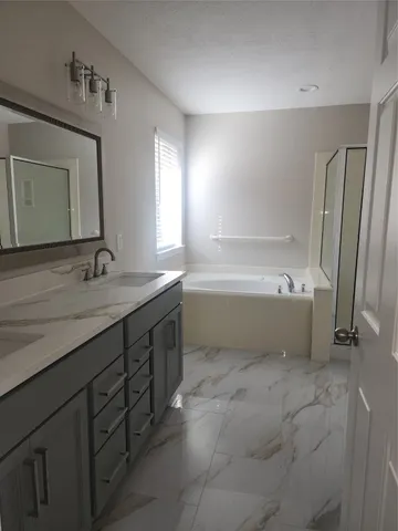a bathroom with a tub sink and mirror