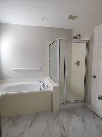 a bathroom with a tub a shower and a sink