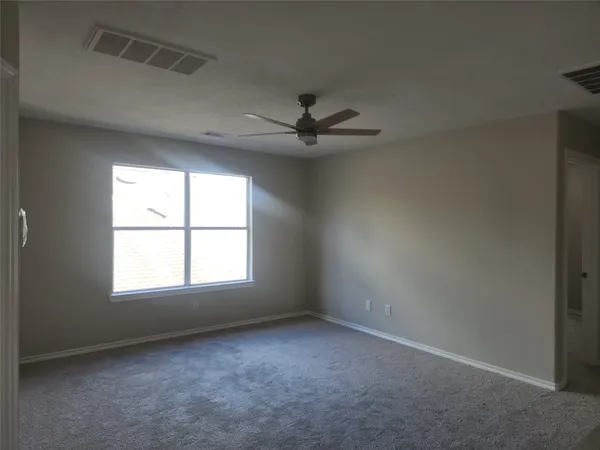 an empty room with a window and a ceiling fan
