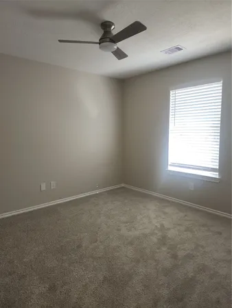 an empty room with a window and a fan