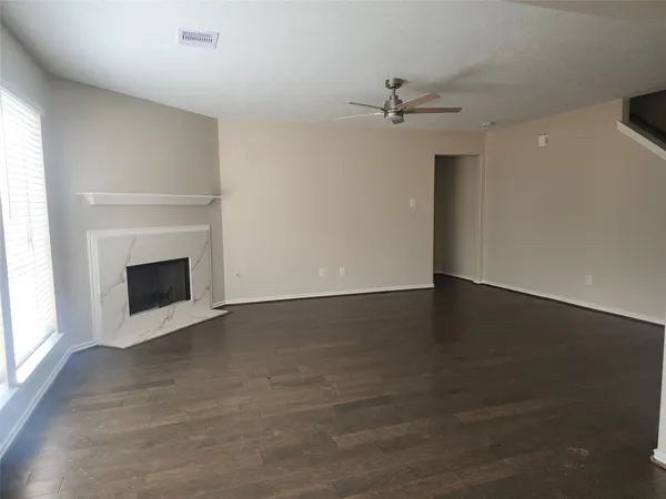 an empty room with windows and fireplace