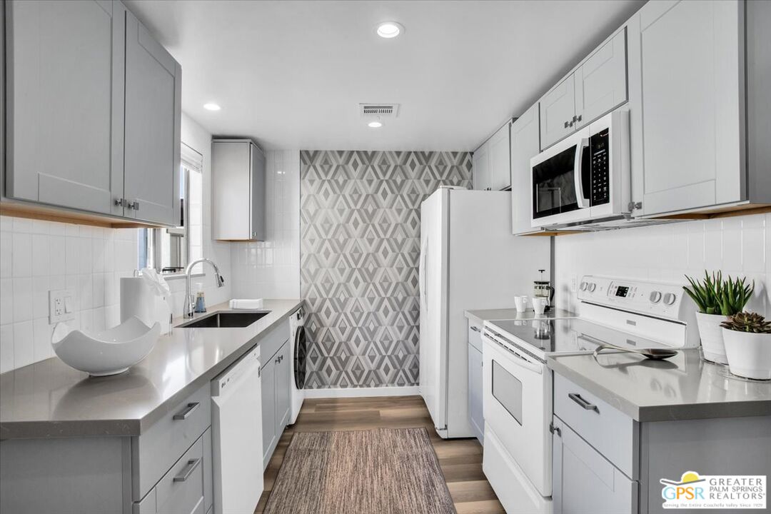 1050 Ramon Road, Unit 116 Palm Springs, CA 92264 - Photo 7 of 34 a kitchen with stainless steel appliances a sink stove and microwave