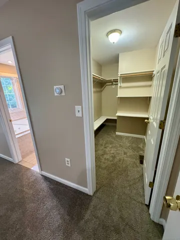 an empty room with walk in closet and a window