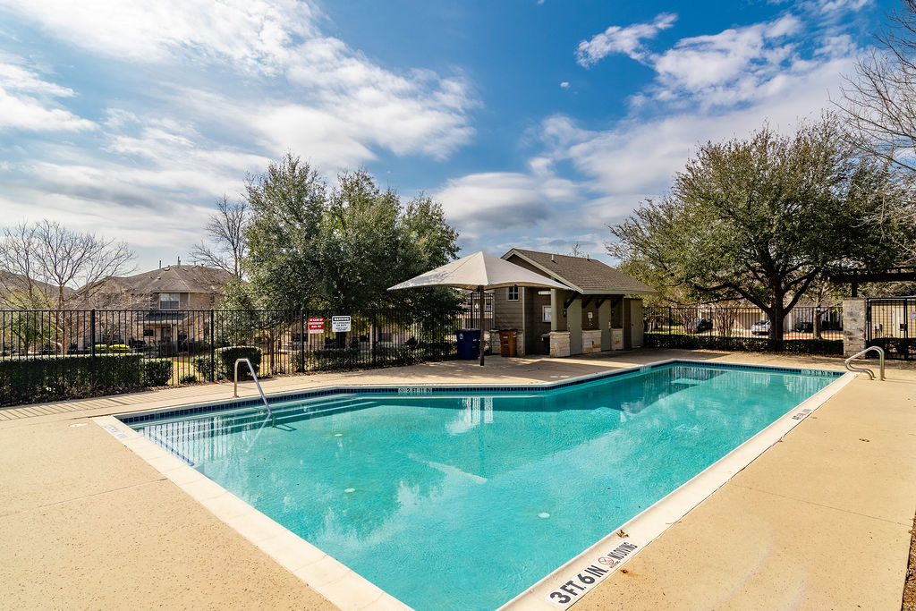 3101 Davis Lane, Unit 8402 Austin, TX 78748 - Photo 23 of 24 a view of a swimming pool with lawn chairs under an umbrella