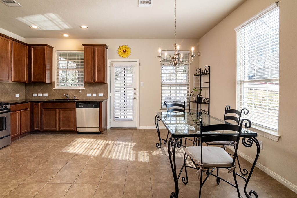 3101 Davis Lane, Unit 8402 Austin, TX 78748 - Photo 8 of 24 a kitchen with a table chairs sink and cabinets