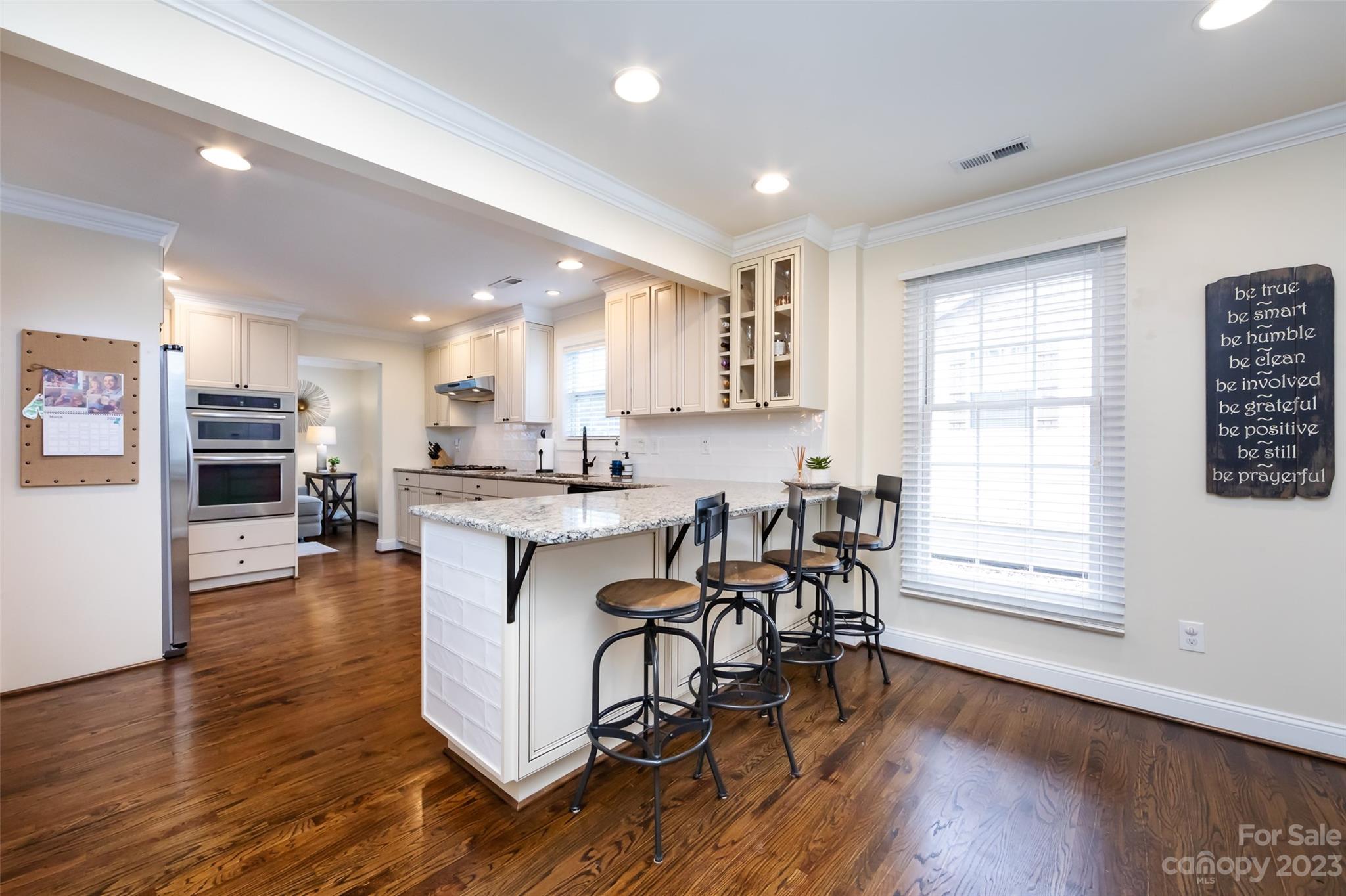 4341 Applegate Road Charlotte, NC 28209 - Photo 17 of 39 a kitchen with stainless steel appliances granite countertop wooden floor a dining table and chairs with wooden floor