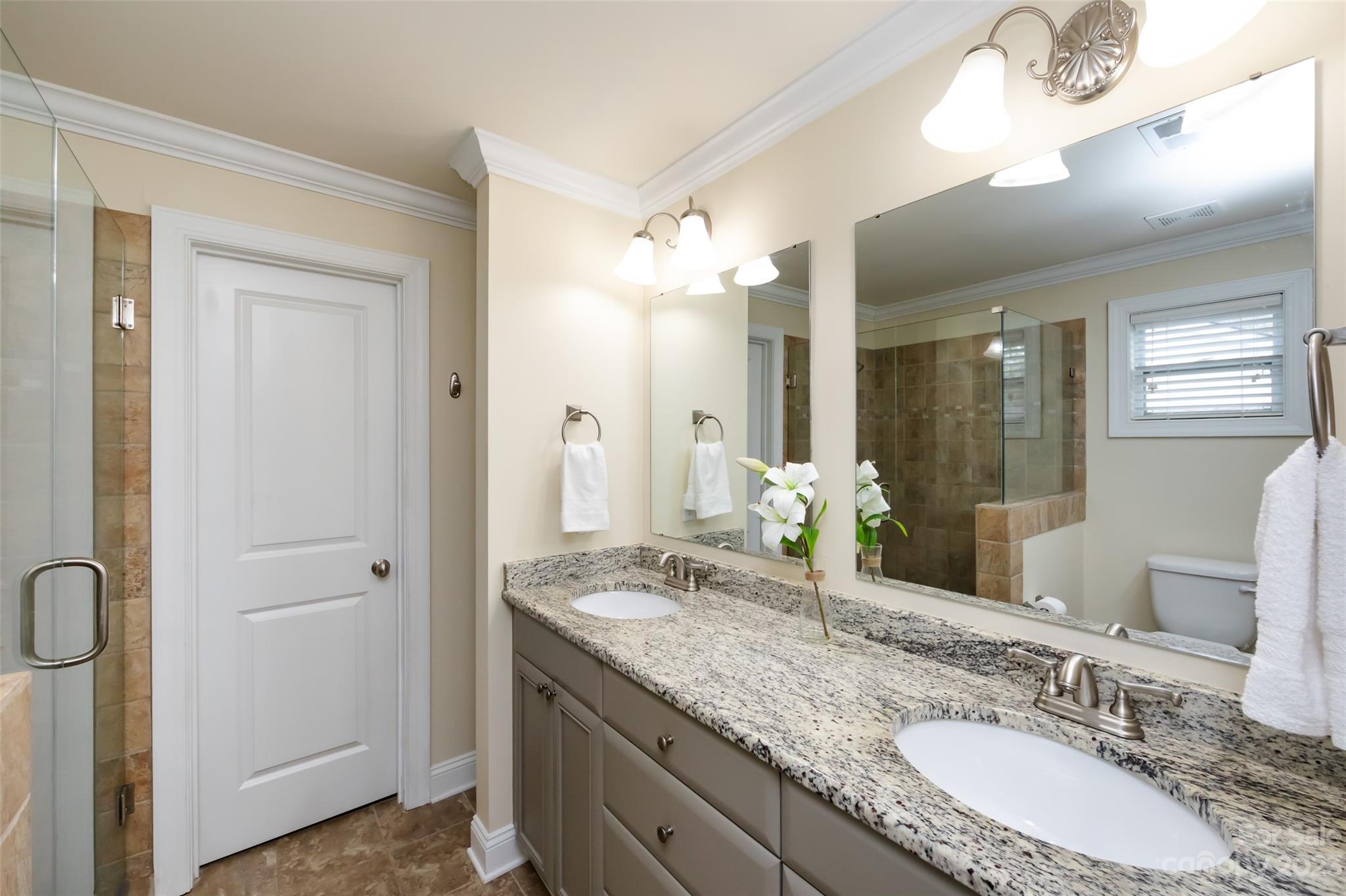 4341 Applegate Road Charlotte, NC 28209 - Photo 25 of 39 a bathroom with a granite countertop sink a large mirror and a shower