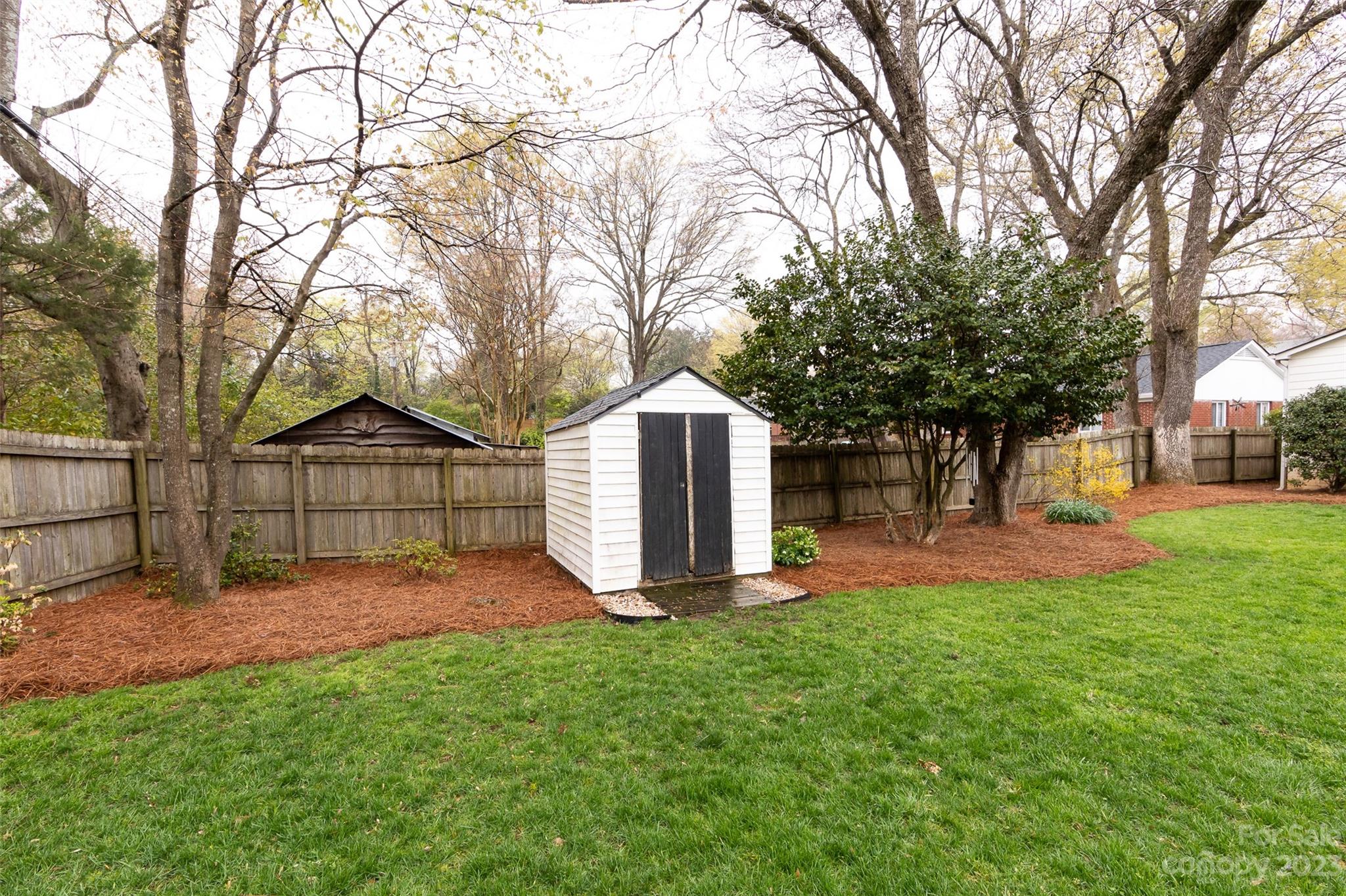 4341 Applegate Road Charlotte, NC 28209 - Photo 37 of 39 a view of a backyard with large trees and a barn in it