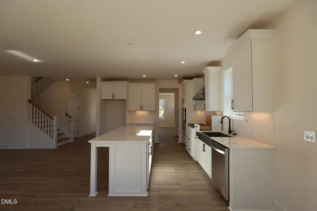 a kitchen with stainless steel appliances kitchen island granite countertop a sink and cabinets