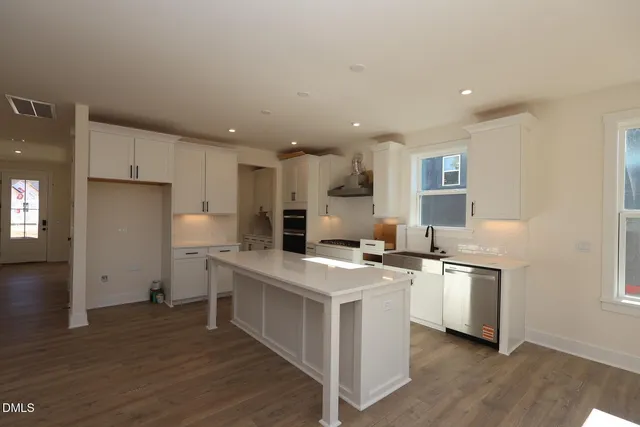 a kitchen with a sink a stove a refrigerator and a cabinets