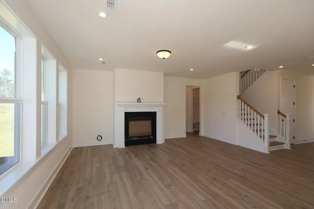 a view of empty room with wooden floor and fireplace
