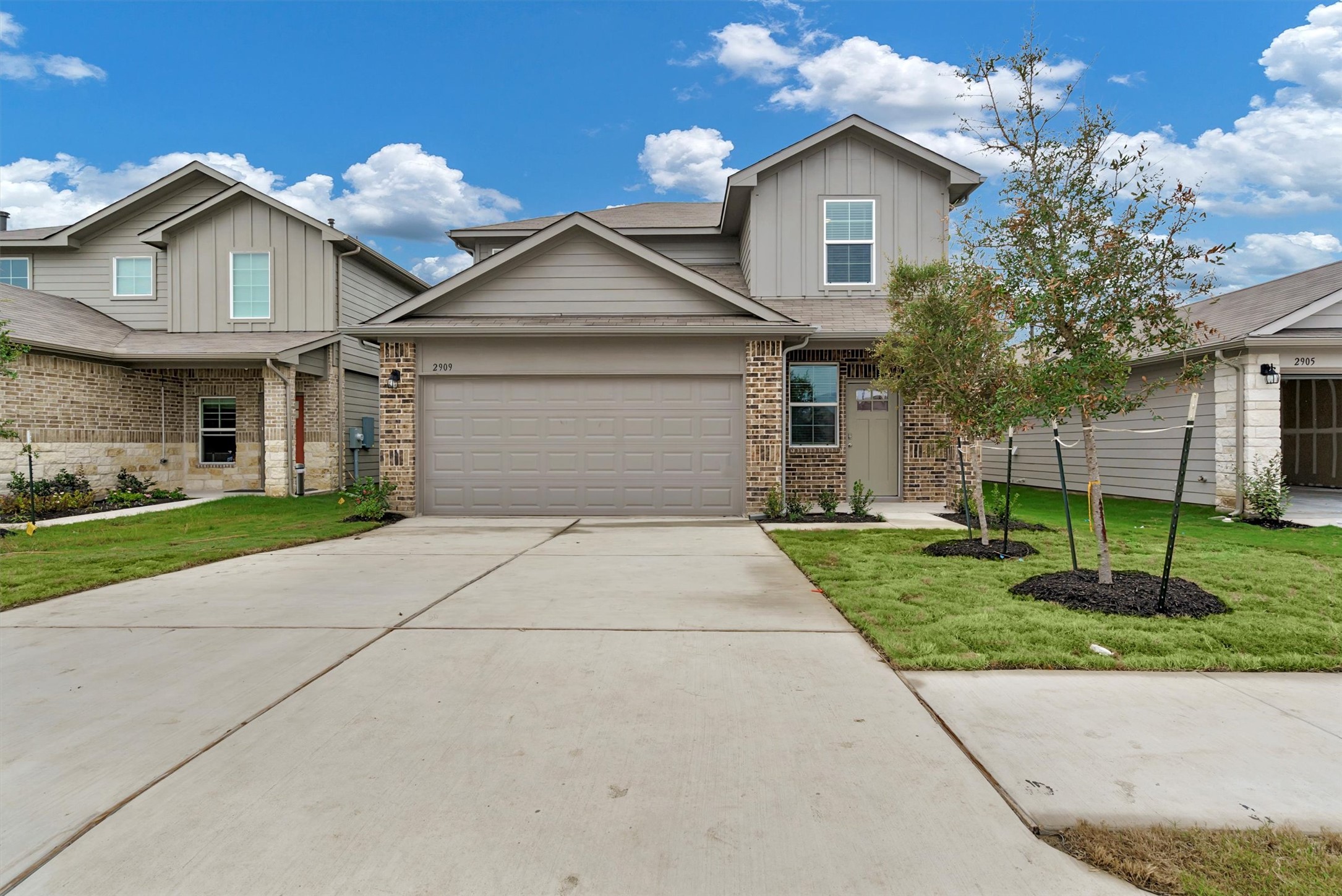 2909 Tweedy Trail Pflugerville, TX 78660 - Photo 2 of 27 A newly constructed residence showcasing a well-maintained lawn and a two-car garage.