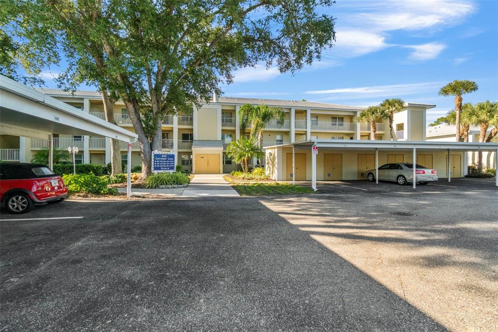 433 Cerromar Lane, Unit 441 Venice, FL 34293 - Photo 1 of 65 a front view of a residential apartment building with a yard