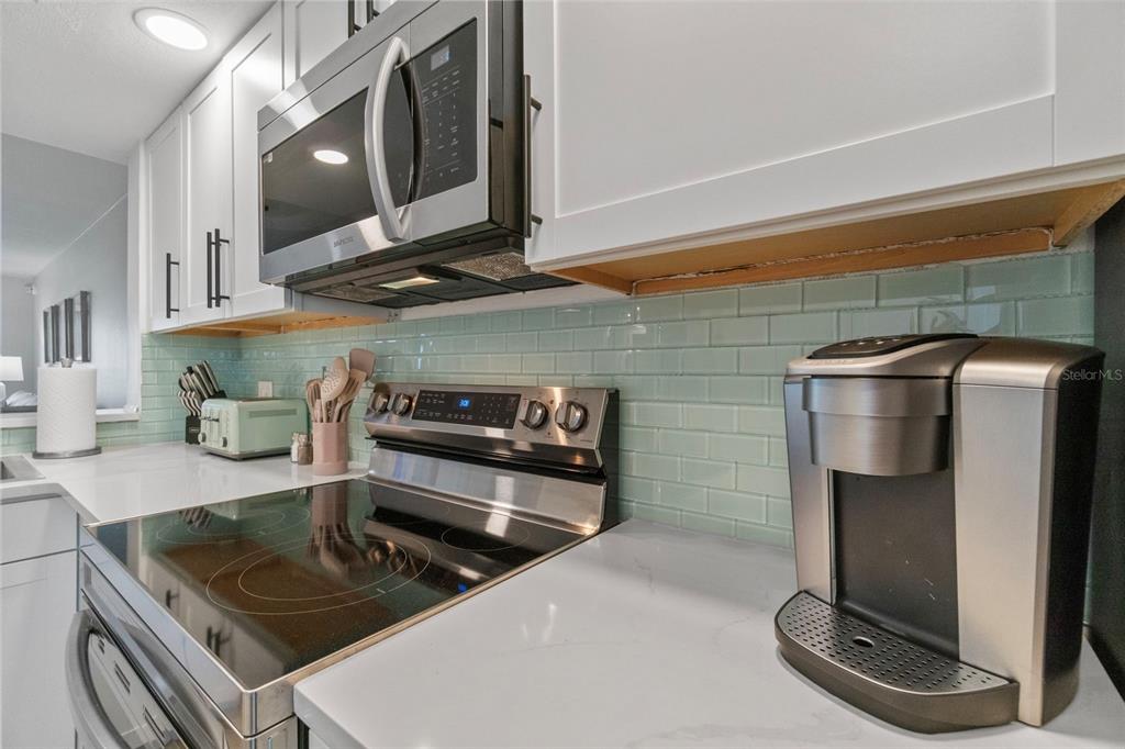 433 Cerromar Lane, Unit 441 Venice, FL 34293 - Photo 13 of 65 a kitchen with stainless steel appliances granite countertop a sink and a stove