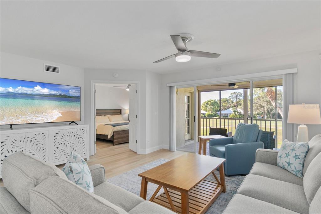 433 Cerromar Lane, Unit 441 Venice, FL 34293 - Photo 26 of 65 a living room with furniture and a flat screen tv