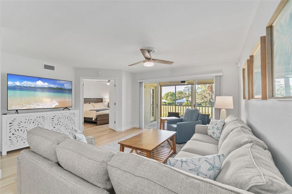 433 Cerromar Lane, Unit 441 Venice, FL 34293 - Photo 27 of 65 a living room with furniture flat screen tv and a large window