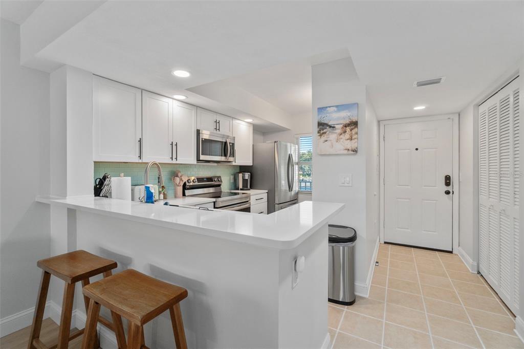 433 Cerromar Lane, Unit 441 Venice, FL 34293 - Photo 3 of 65 a kitchen with stainless steel appliances a sink a stove a refrigerator cabinets and a dining table