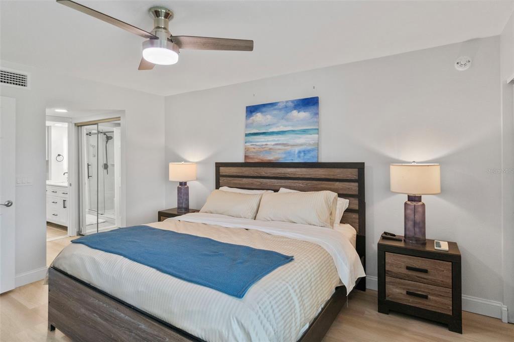 433 Cerromar Lane, Unit 441 Venice, FL 34293 - Photo 32 of 65 a bedroom with a bed and a lamp on table