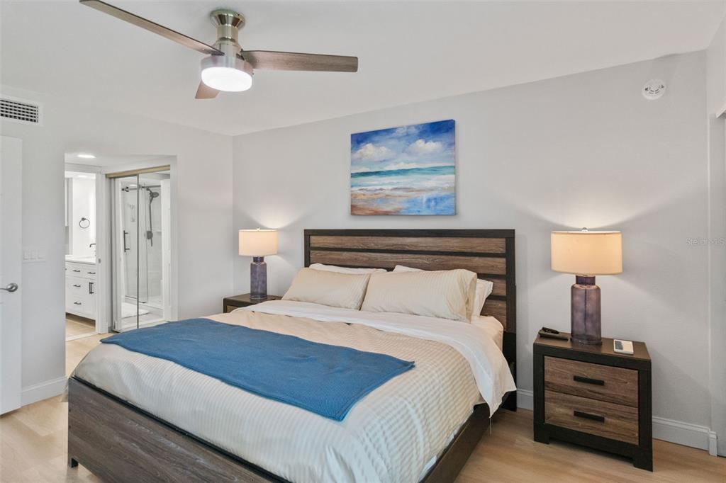 433 Cerromar Lane, Unit 441 Venice, FL 34293 - Photo 34 of 65 a bedroom with a bed and a lamp on dresser