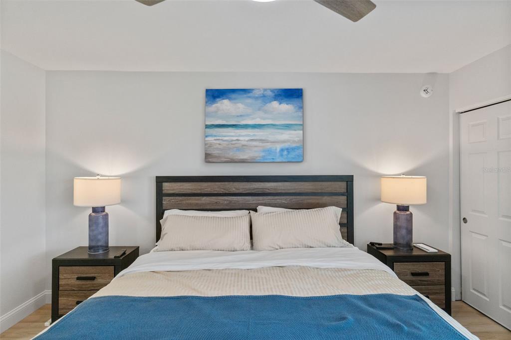 433 Cerromar Lane, Unit 441 Venice, FL 34293 - Photo 35 of 65 a bedroom with a bed and a night stand