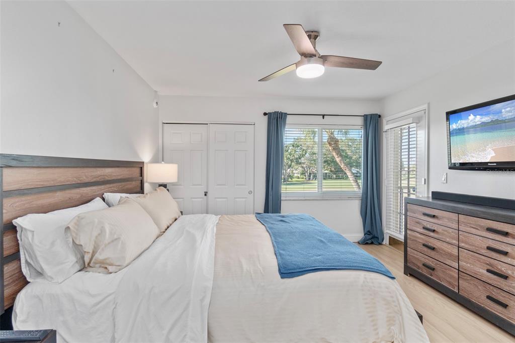 433 Cerromar Lane, Unit 441 Venice, FL 34293 - Photo 38 of 65 a bedroom with a large bed and a flat tv screen on dresser