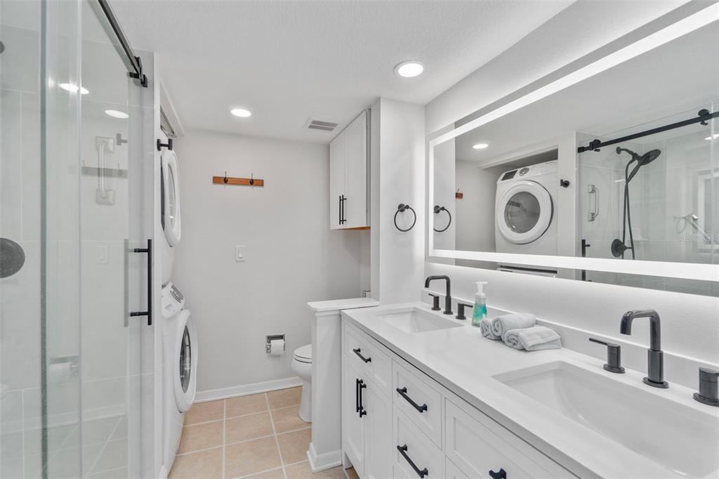 433 Cerromar Lane, Unit 441 Venice, FL 34293 - Photo 41 of 65 a bathroom with a double vanity sink mirror and shower