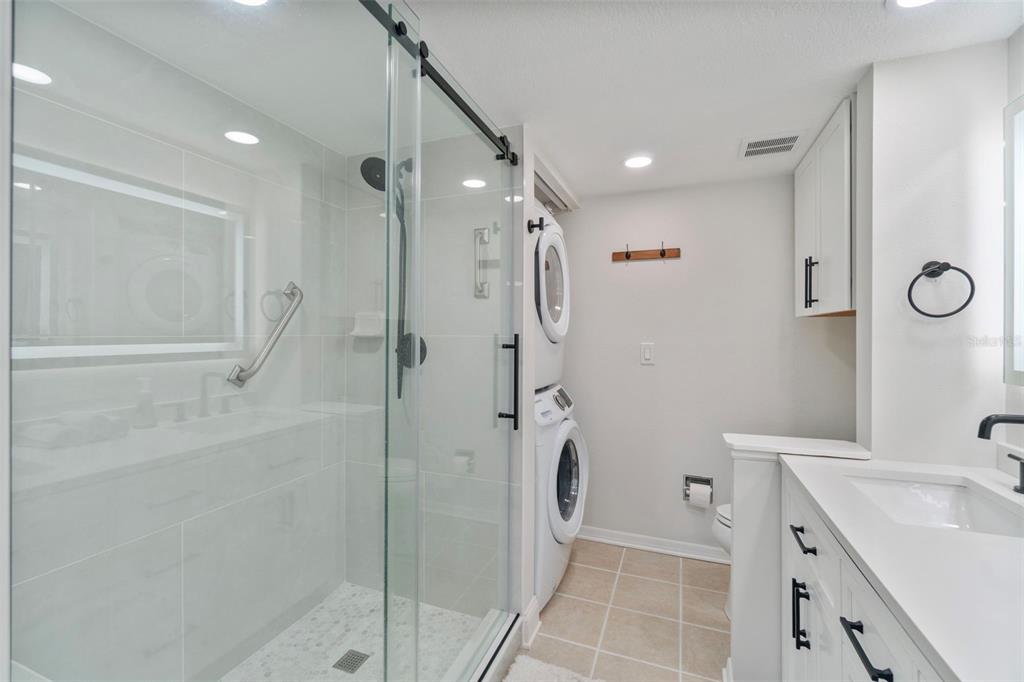 433 Cerromar Lane, Unit 441 Venice, FL 34293 - Photo 42 of 65 a bathroom with a shower sink and mirror