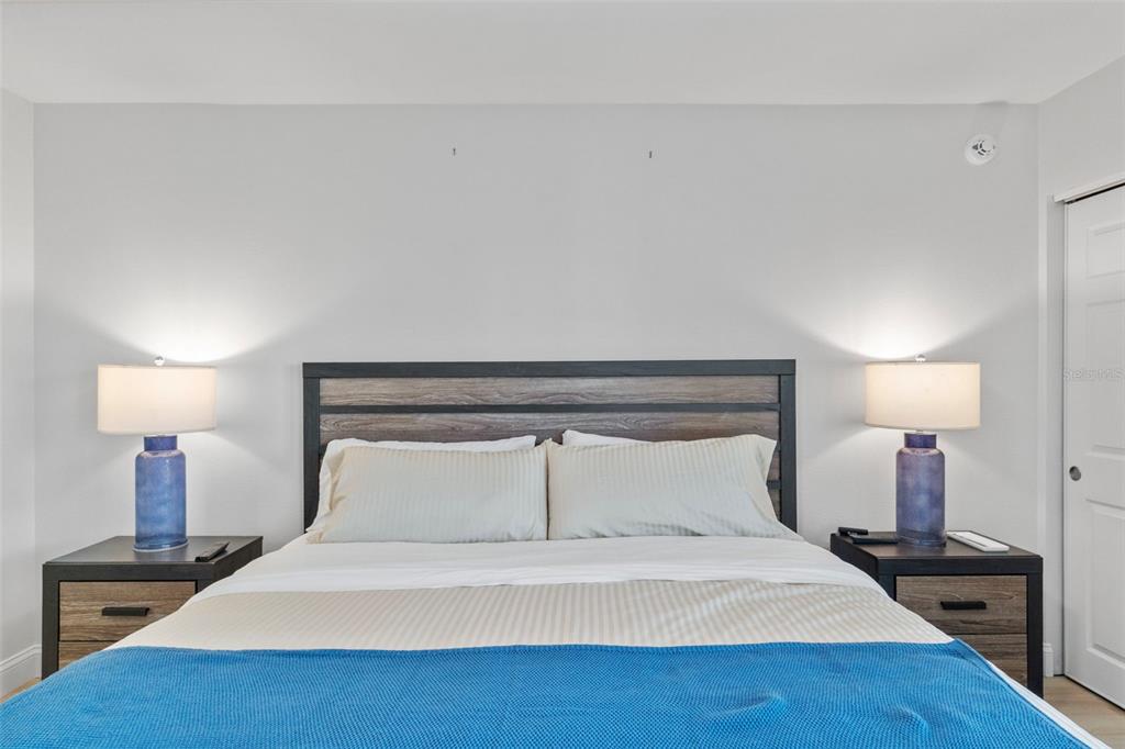 433 Cerromar Lane, Unit 441 Venice, FL 34293 - Photo 46 of 65 a bedroom with a bed and a lamp