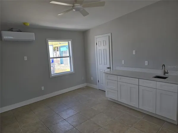 an empty room with windows and fan