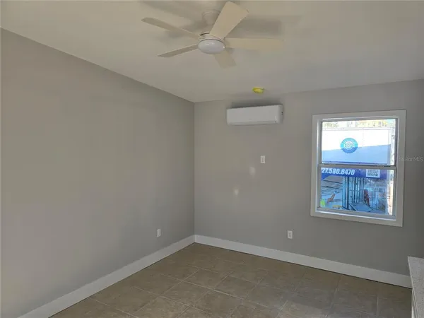 an empty room with windows and fan