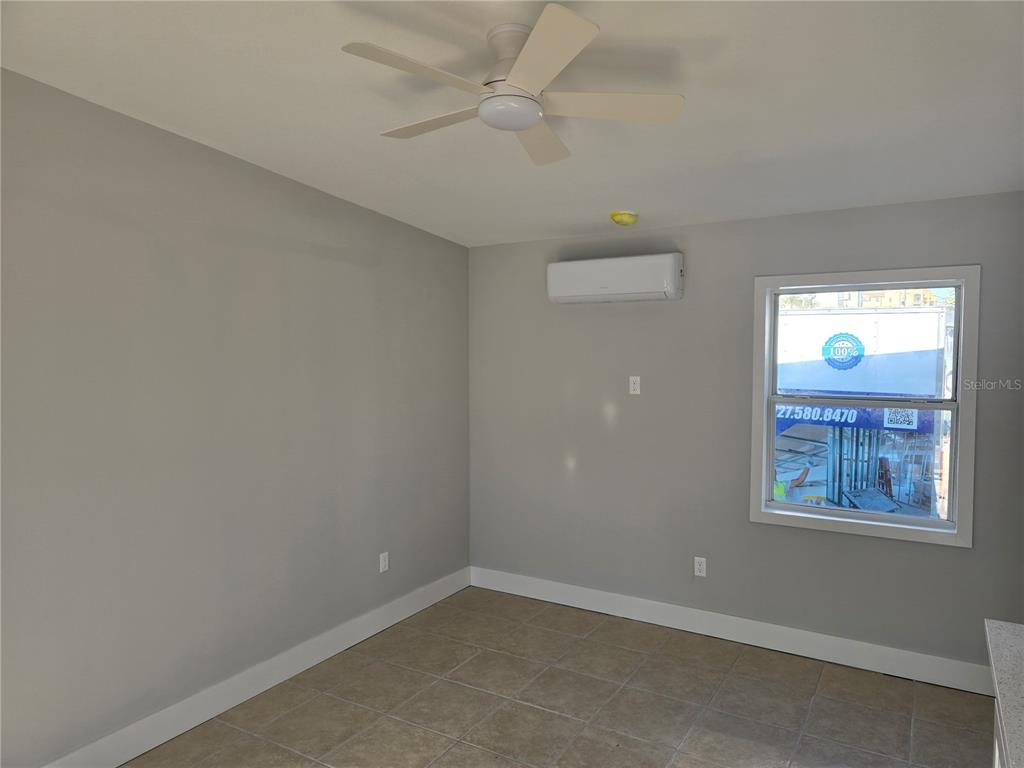 13343 Gulf Boulevard, Unit A1 St. Petersburg, FL 33708 - Photo 4 of 8 an empty room with windows and fan