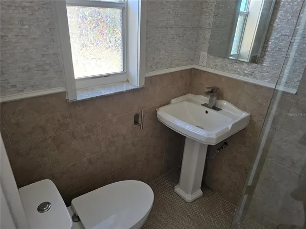 a bathroom with a toilet sink and mirror