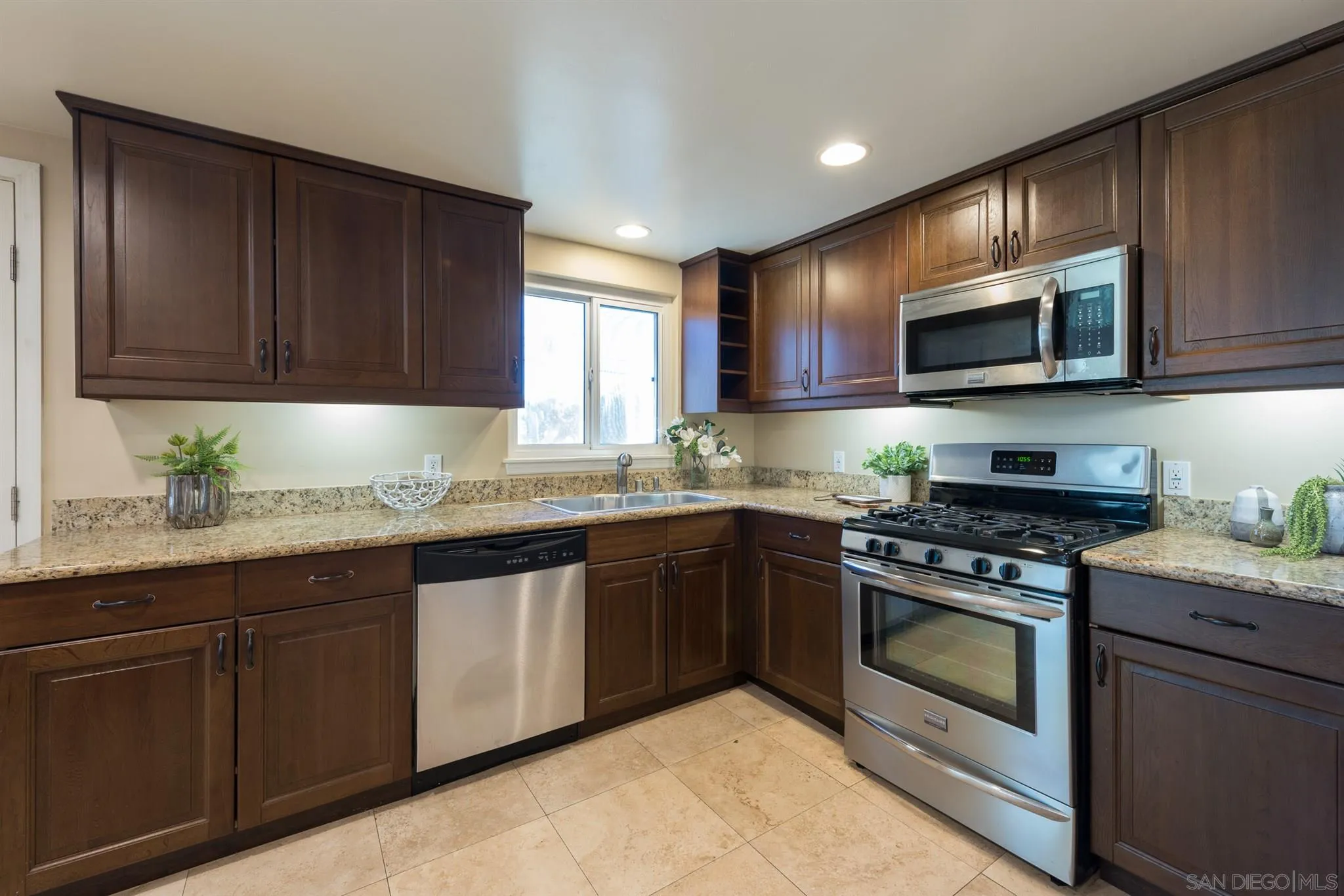 2661 Murray Ridge Road San Diego, CA 92123 - Photo 8 of 23 a kitchen with granite countertop wooden cabinets and stainless steel appliances