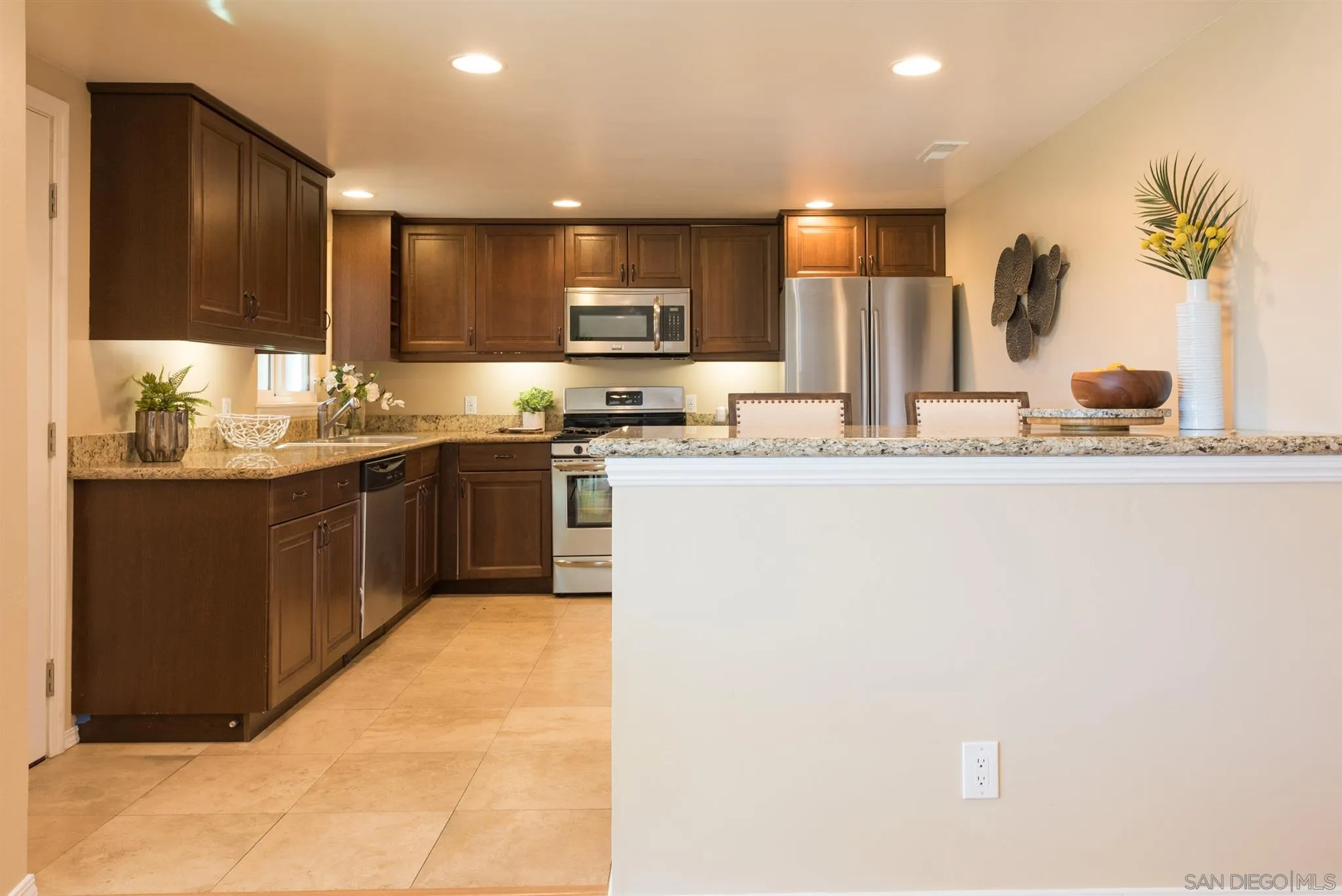 2661 Murray Ridge Road San Diego, CA 92123 - Photo 9 of 23 a kitchen with kitchen island granite countertop a sink and cabinets