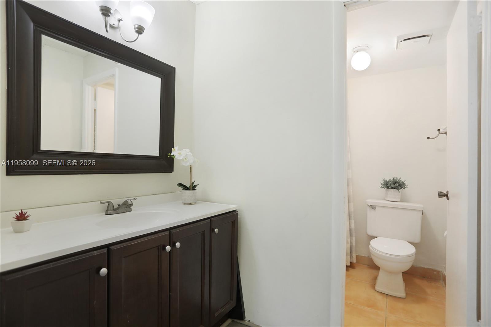 6600 Cypress Road, Unit 105 Plantation, FL 33317 - Photo 17 of 51 a bathroom with a toilet sink and mirror
