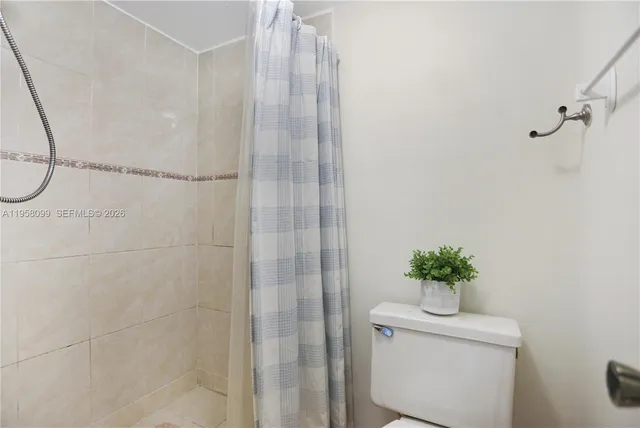 a bathroom with a shower curtain and a toilet