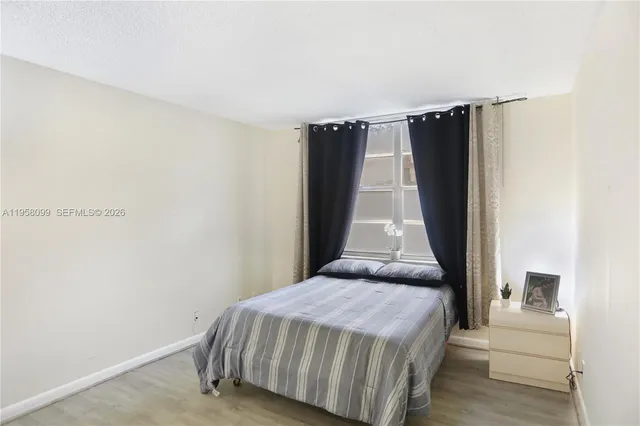 a bedroom with a bed and a black wall painting