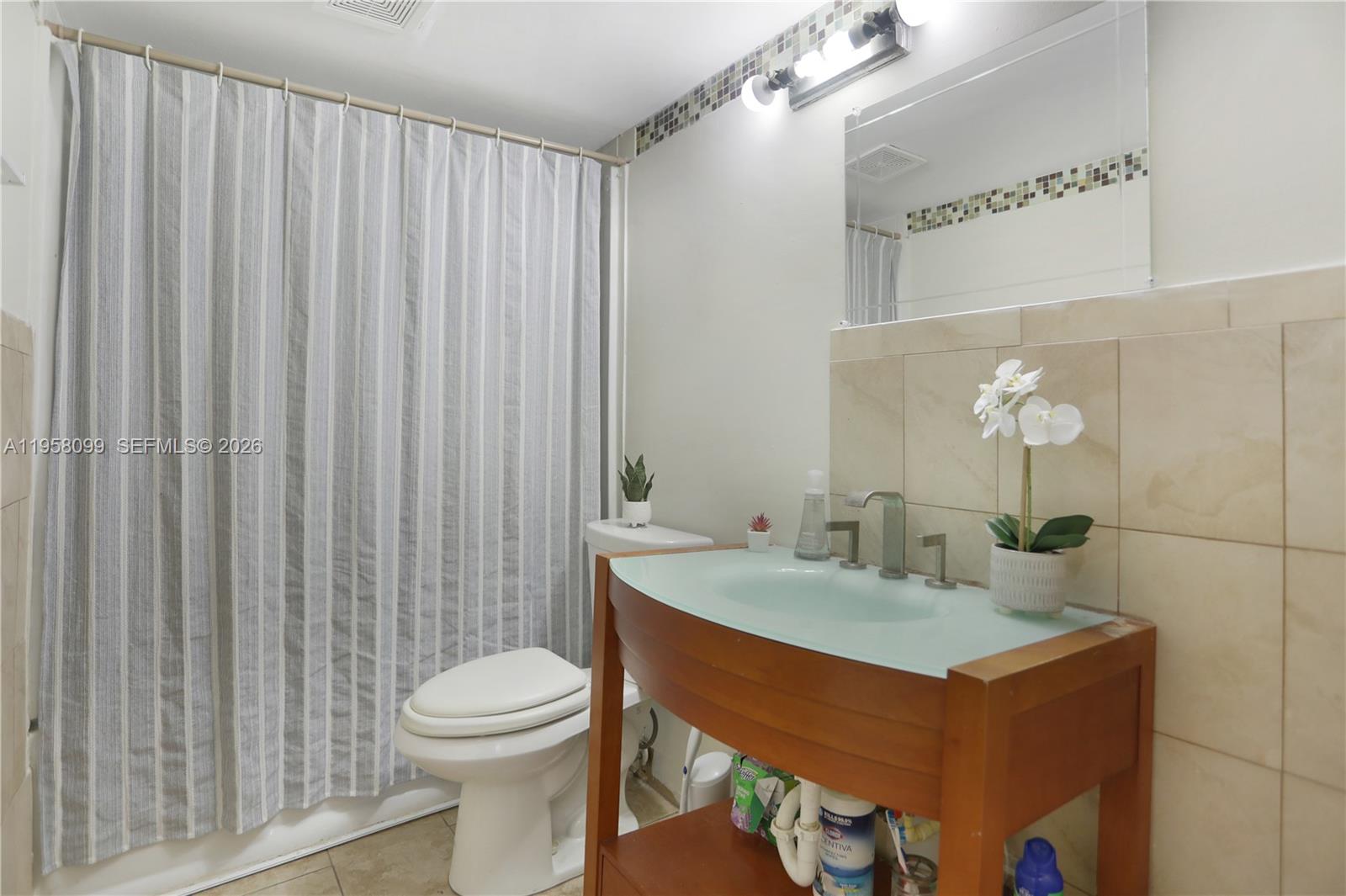 6600 Cypress Road, Unit 105 Plantation, FL 33317 - Photo 42 of 51 a bathroom with a sink a toilet and shower curtain