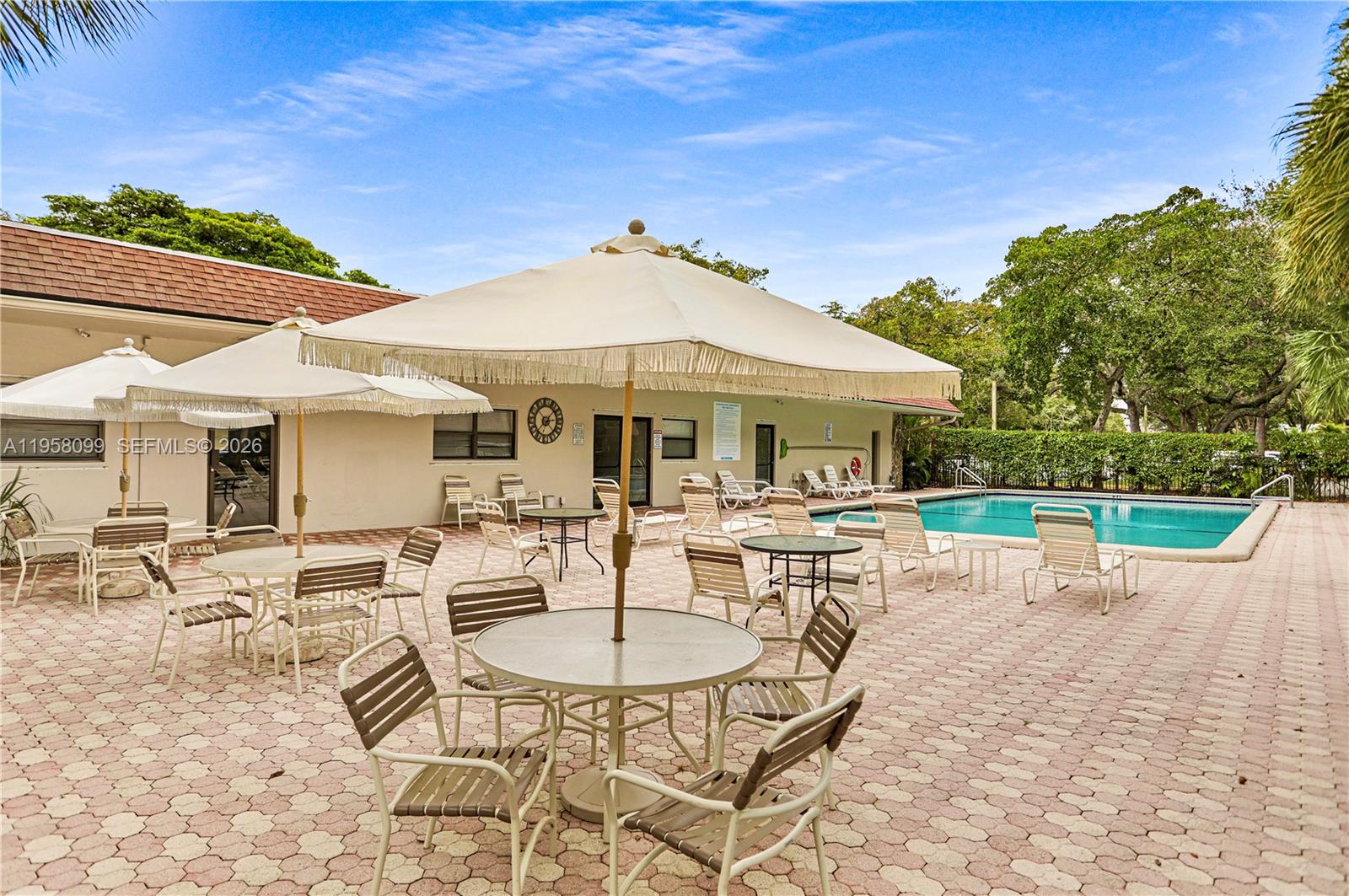 6600 Cypress Road, Unit 105 Plantation, FL 33317 - Photo 46 of 51 a patio with a table and chairs under an umbrella