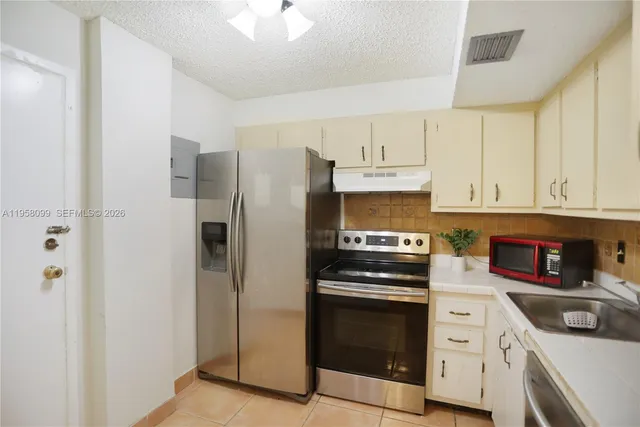 a kitchen with cabinets stainless steel appliances and a counter space