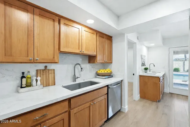 a kitchen with stainless steel appliances granite countertop a sink and a stove top oven with wooden floor