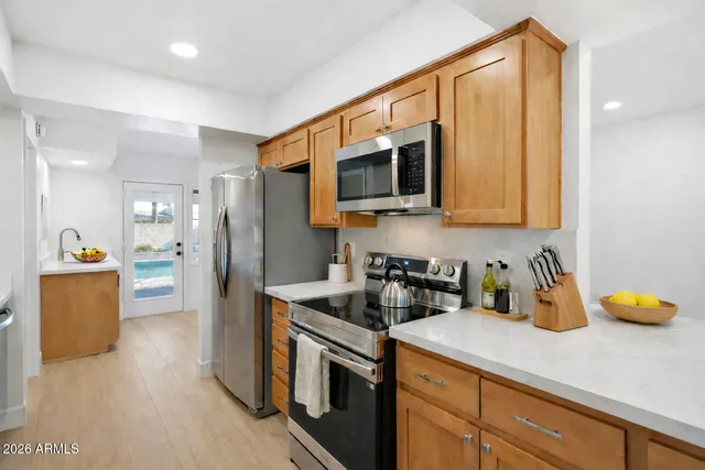 a view of a big room with wooden floor and windows