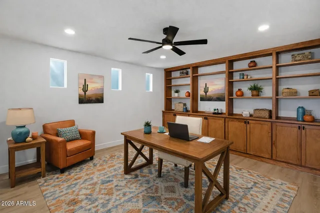 a view of empty room with wooden floor and ceiling fan