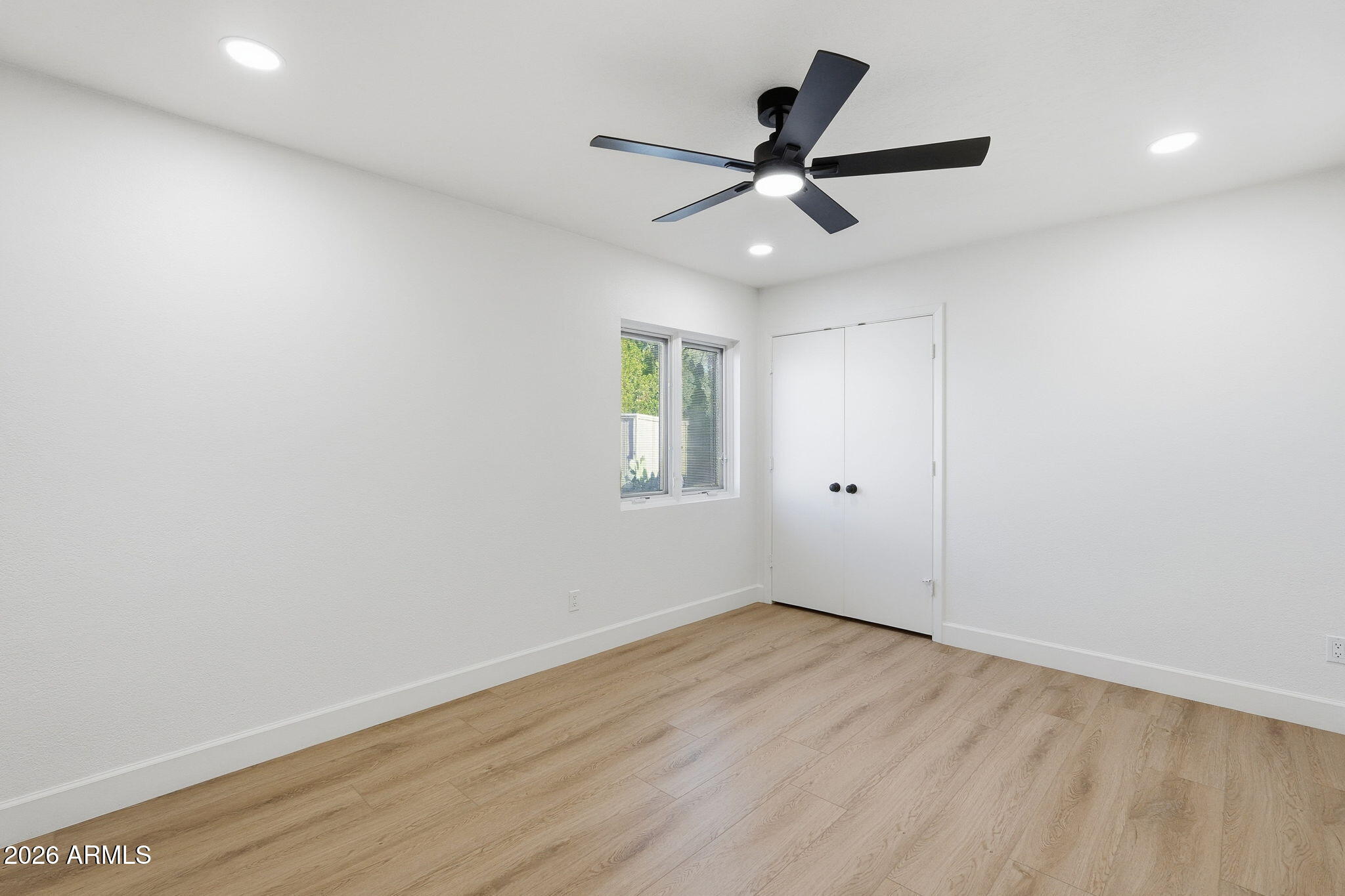 6615 East Phelps Road Scottsdale, AZ 85254 - Photo 32 of 53 an empty room with wooden floor fan and windows