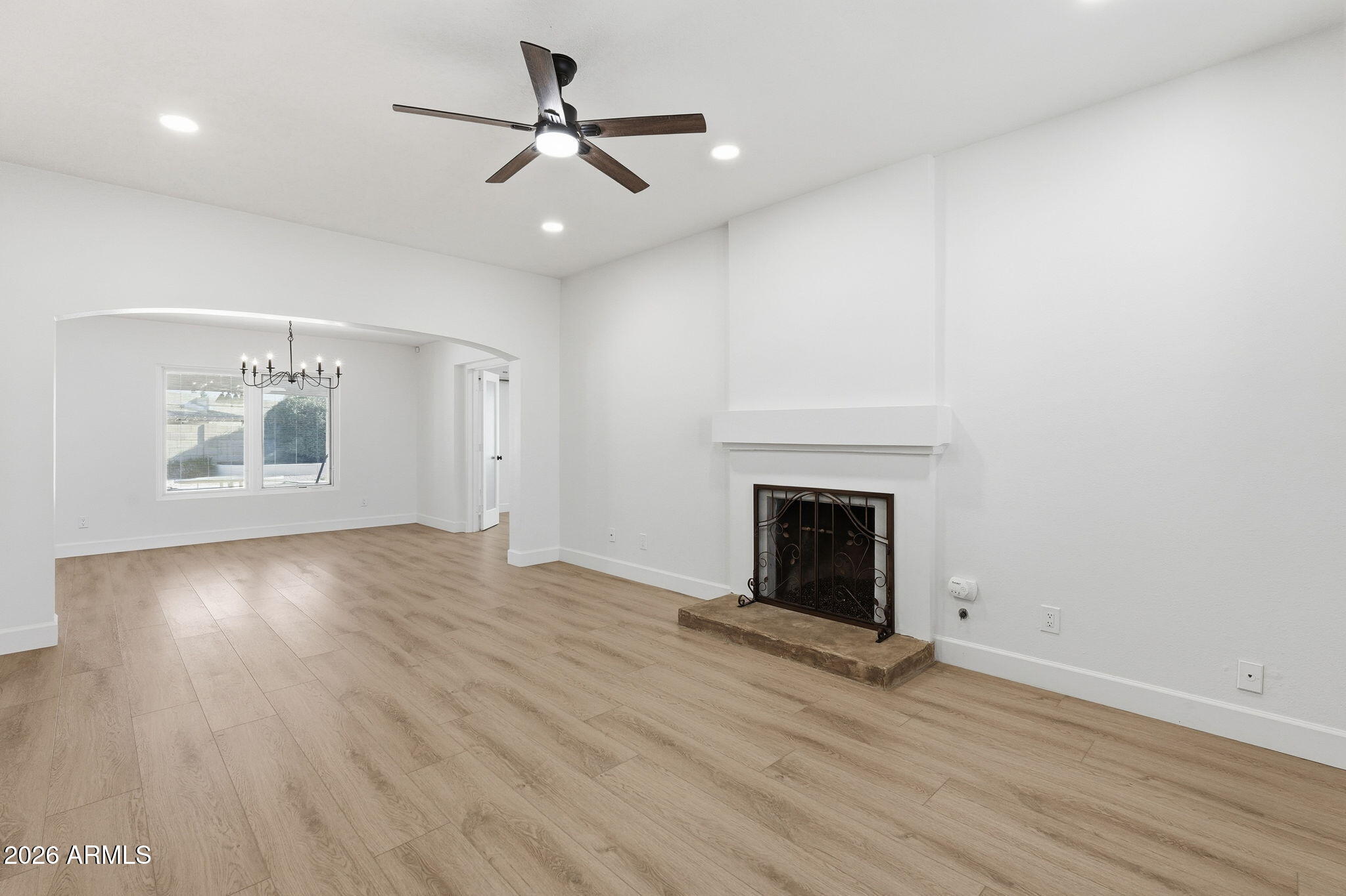 6615 East Phelps Road Scottsdale, AZ 85254 - Photo 7 of 53 an empty room with wooden floor fireplace and windows
