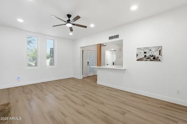 a kitchen with stainless steel appliances granite countertop white cabinets a sink and dishwasher with wooden floor
