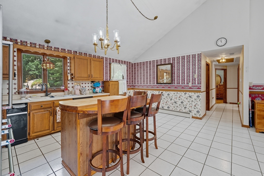 45 Red Gate Road Tyngsborough, MA 01879 - Photo 12 of 42 a dining hall with stainless steel appliances a stove a sink dishwasher with a dining table and chairs